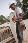 Carpenter moving a particle board at a building construction site — Stock Photo