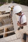 Carpenter putting a particle board in place at a building construction site — Stock Photo