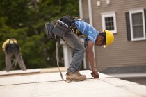Carpenter measuring a particle board for trimming at a building construction site — Stock Photo