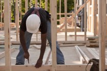 Измерения плотника на древесине на строительной площадке — стоковое фото