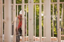 Carpenter measuring frames at a building construction site — Stock Photo