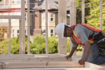 Carpenter placing wall studs in a wall frame at a building construction site — Stock Photo