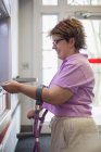 Femme atteinte de paralysie cérébrale utilisant un distributeur automatique de billets — Photo de stock