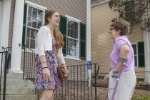 Frau mit Zerebralparese im Gespräch mit ihrer Schwester vor einem Haus — Stockfoto