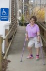 Donna con paralisi cerebrale che cammina lungo una rampa accessibile — Foto stock