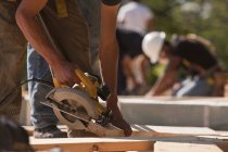 Carpenters using circular saw at a construction site — Stock Photo