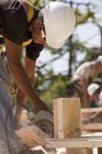 Carpenter using a circular saw at a construction site — Stock Photo