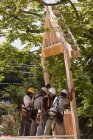 Carpinteiros que levantam a estrutura de telhadura em um canteiro de obras — Fotografia de Stock