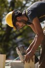 Carpenter using a nail gun at a construction site — Stock Photo