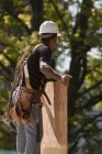 Carpenter carrying a particle board at a construction site — Stock Photo