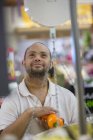 Homme trisomique pesant des légumes dans une épicerie — Photo de stock