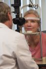 Augenarzt untersucht mit Spaltlampe die Augen einer Frau — Stockfoto