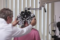 Ophtalmologiste plaçant le phoropter devant une patiente — Photo de stock