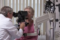 Oftalmologo che esamina un occhio femminile con un cheratometro — Foto stock