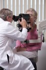 Ophtalmologiste examinant les yeux d'une femme avec un kératomètre — Photo de stock