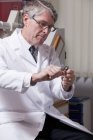 Офтальмолог вскрывает флакон с ботоксом в клинике — стоковое фото