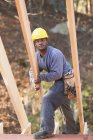 Carpinteiro colocando uma viga para a construção da casa — Fotografia de Stock