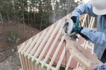 Carpenter using a circular saw to recut rafter bevel, cropped image — Stock Photo