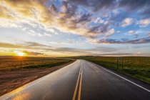 Winding country road at sunset; Val Marie, Saskatchewan, Canada — Stock Photo