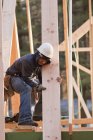 Carpenter moving roof rafter into place — Stock Photo