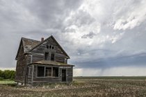Ancienne ferme dans les Prairies sous les nuages orageux ; Val Marie, Alberta, Canada — Photo de stock