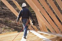 Carpenter with a nail gun at roof level — Stock Photo
