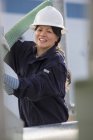 Female power engineer moving flexible pipe at power plant — Stock Photo
