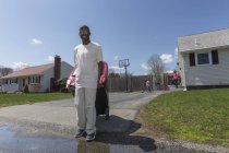 Mann mit Williams-Syndrom räumt mit Familie im Hintergrund den Müll raus — Stockfoto