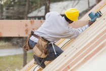Carpenter using a circular saw on beam — Stock Photo
