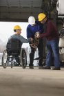 Maintenance supervisors one with spinal cord injury moving tow chain in utility truck garage — Stock Photo