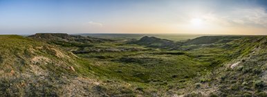 Paesaggio immenso che si estende fino all'orizzonte al tramonto nel Parco Nazionale delle Grassland; Val Marie, Saskatchewan, Canada — Foto stock