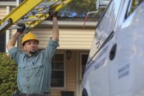 Lineman getting ladder from truck at site — Stock Photo