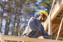Carpentiere misura lunghezza trave per la costruzione di case — Foto stock