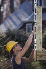 Carpinteiro hispânico usando um nível na construção do posto de convés — Fotografia de Stock