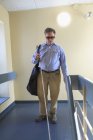 Homem com cegueira congênita usando sua bengala em um corredor de apartamento — Fotografia de Stock