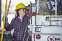 Female power engineer putting tools into a bucket truck — Stock Photo