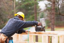 Carpenter using a nail gun to frame house — Stock Photo