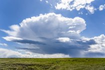 Vastos campos de terras agrícolas nas pradarias sob um grande céu com formações de nuvens e uma tempestade à distância; Val Marie, Saskatchewan, Canadá — Fotografia de Stock