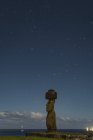 Un seul moai la nuit contre un ciel étoilé ; Île de Pâques, Chili — Photo de stock