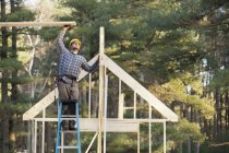 Carpenter assembling roof structure for house construction — Stock Photo