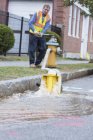 Water department technician opening fire hydrant to flush water mains — Stock Photo