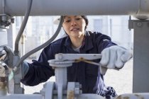 Female power engineer adjusting pressure valve at power station — Stock Photo