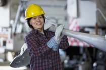 Female power engineer moving a street lamp in service garage — Stock Photo