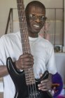 Junger Mann mit Williams-Syndrom spielt seine E-Gitarre — Stockfoto