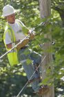 Linienrichter an einem Mast arbeitet an Telefon- und Kabeldrähten — Stockfoto