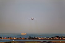 Avión despegando desde el aeropuerto Logan con Winthrop, Boston, Massachusetts, EE.UU. - foto de stock