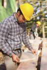 Carpenter preparing bevel cut for a rafter of a house — Stock Photo