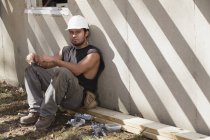Carpinteiro hispânico fazendo uma pausa no local de construção — Fotografia de Stock