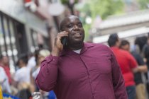 Hombre con TDAH hablando en un teléfono móvil en la calle de la ciudad - foto de stock