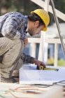 Carpinteiro de medição no plano de casa para a construção da casa — Fotografia de Stock